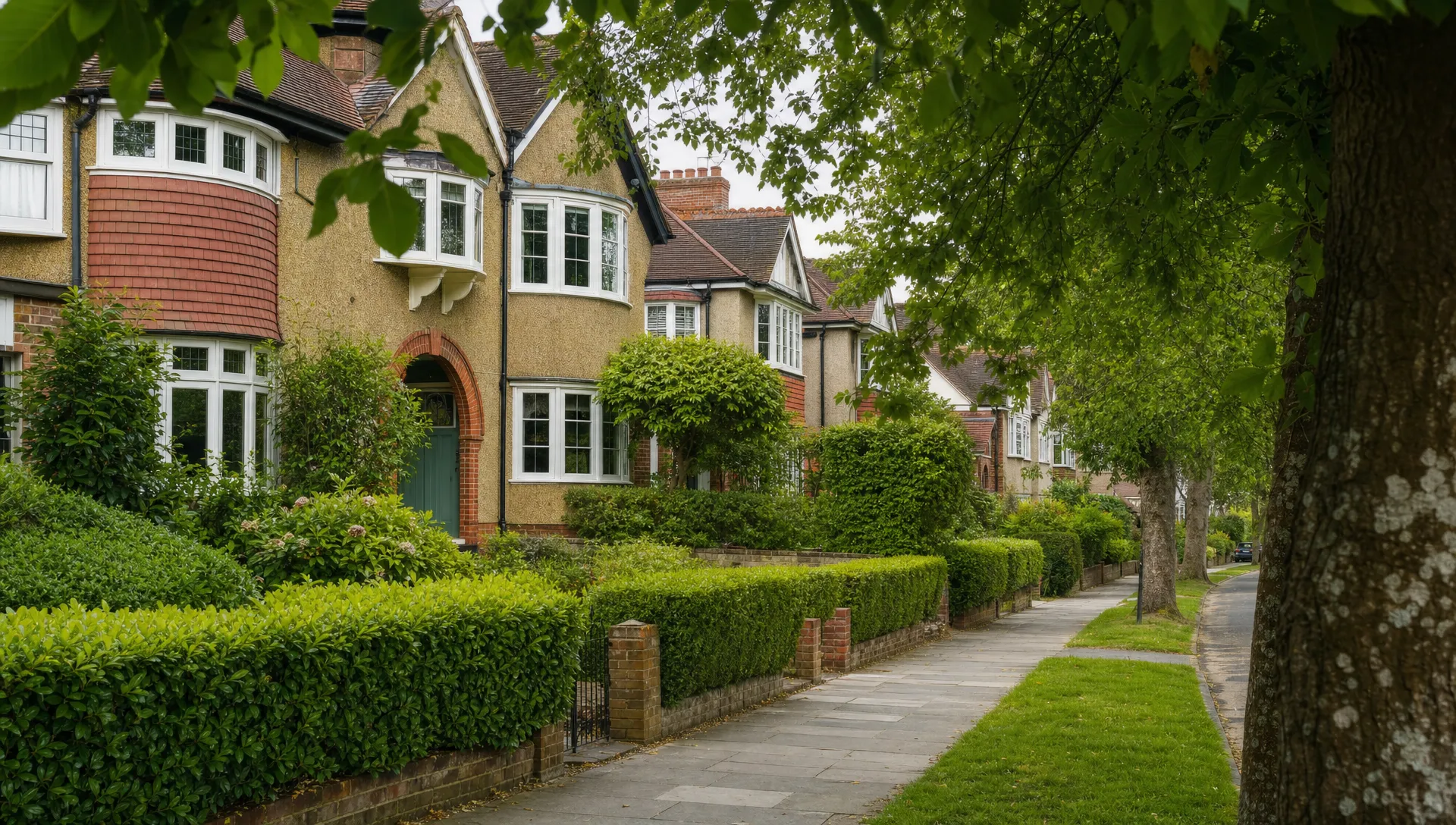 A quiet Ickenham residential street with well-kept 1930s semi-detached homes, front gardens and mature hedges.