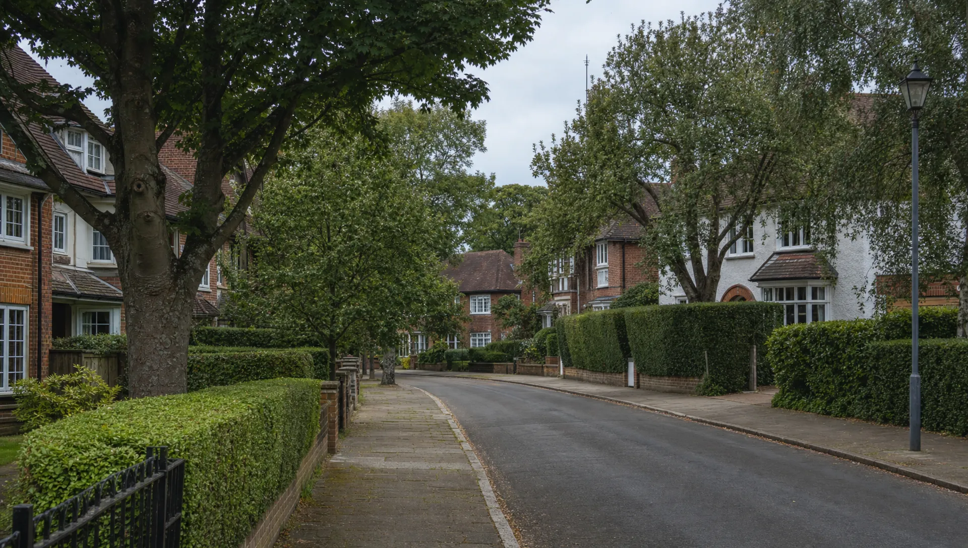 A quiet Ickenham residential street with period homes, clipped hedges and mature trees.