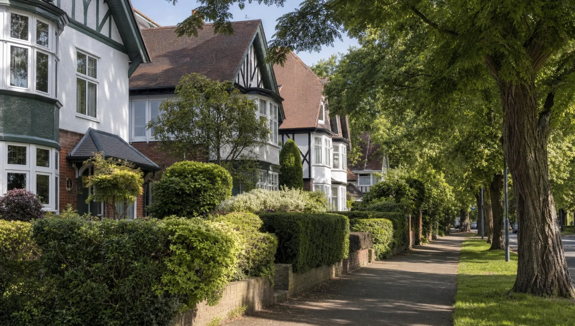 A quiet tree-lined residential street in Ickenham with 1930s detached and semi-detached homes, bay windows, mature hedges, tidy front gardens and no people or vehicles dominating the scene.